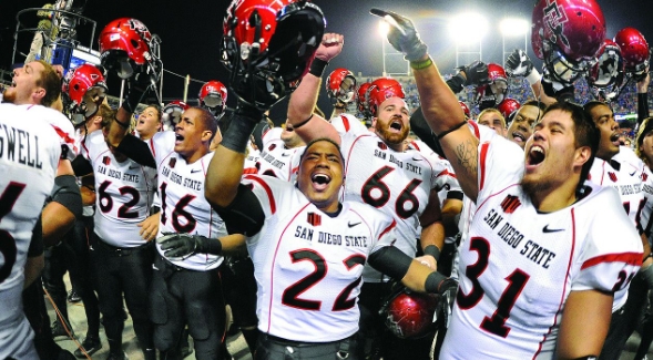 The football team cheers in excitement.