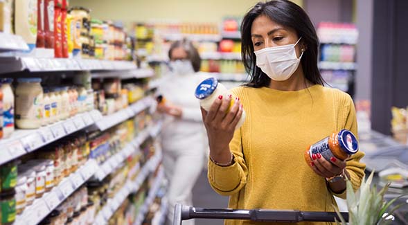 Soaring inflation is socking American consumers at every turn. Above, a woman considers products for sale in a supermarket. (Adobe Stock Images)