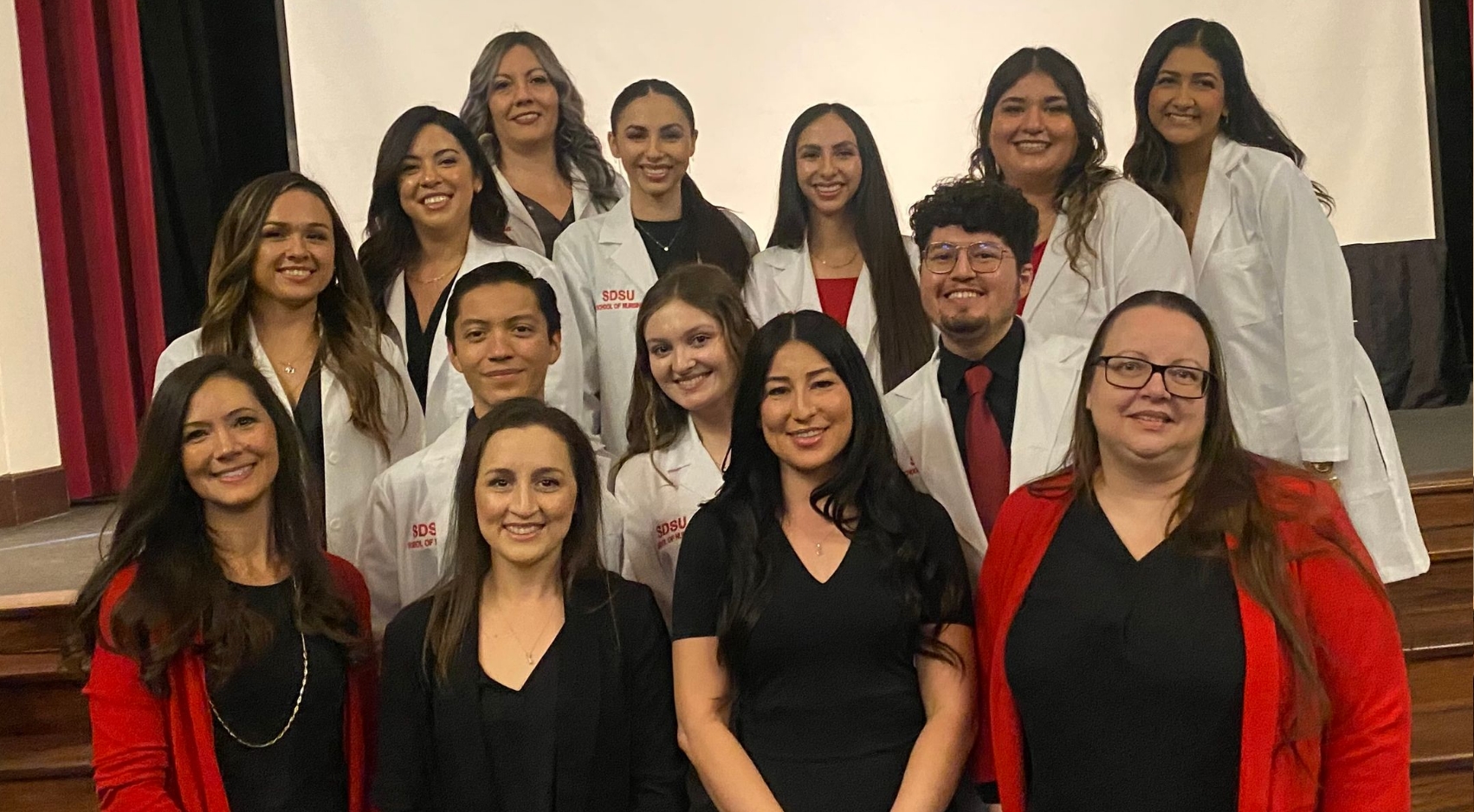 Students in SDSU Imperial Valley's new accelerated Bachelors of Nursing program pose in their white coats, along with their instructors
