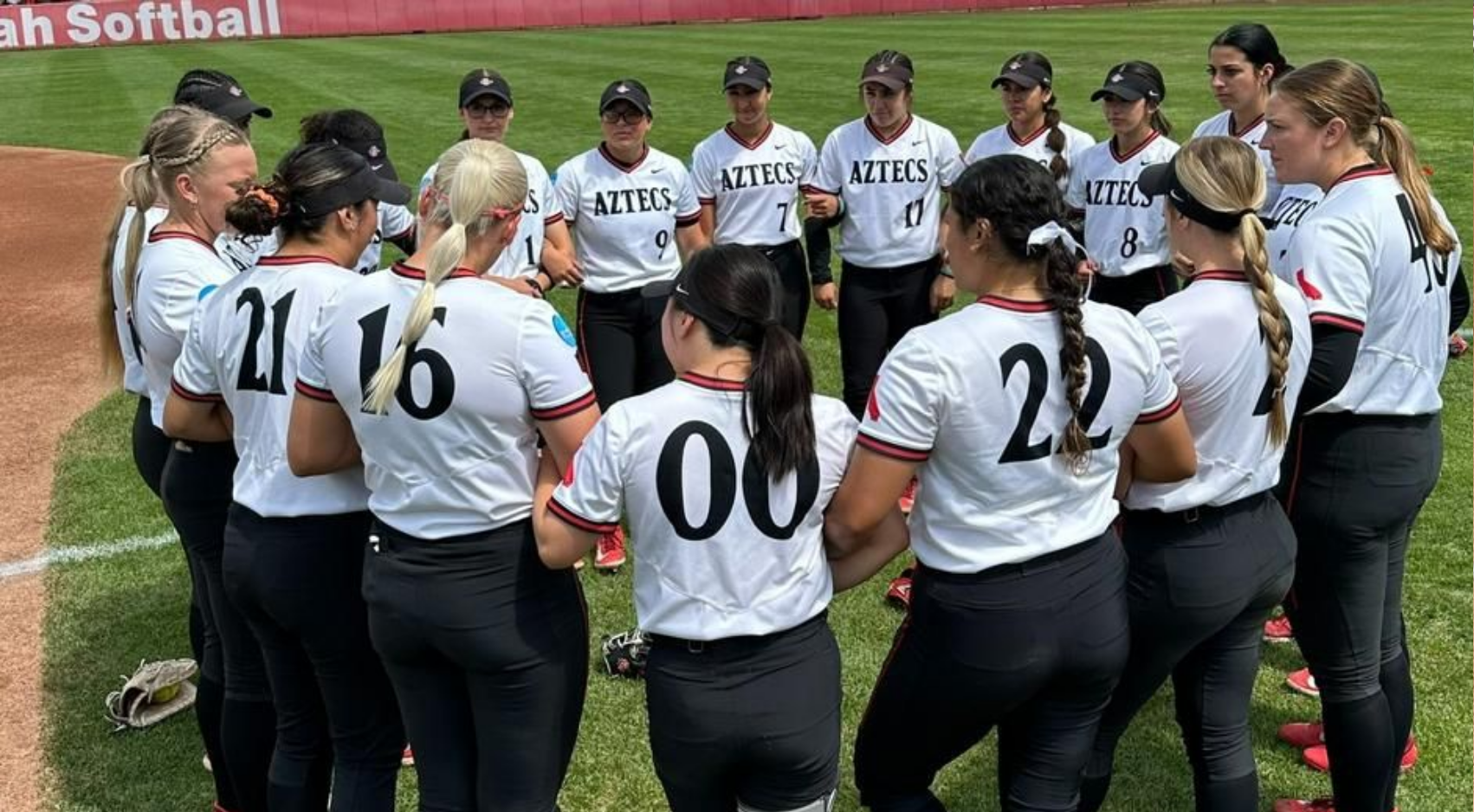 The SDSU softball team huddles on the field at Dumke Family Softball Stadium ahead of their NCAA Salt Lake City Regional final against Utah. (SDSU)