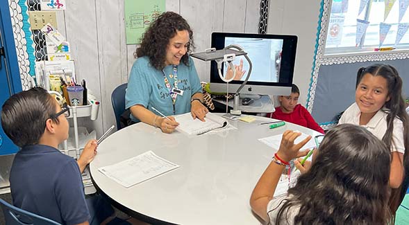 Rafdely Aguilar (center) gave a multiplication lesson to fifth graders at Mae L. Feaster Charter School in Chula Vista.