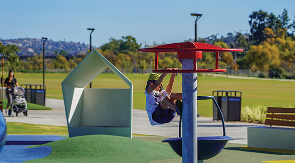A young parkgoer hanging out on one of the structures in the play area. (SDSU)