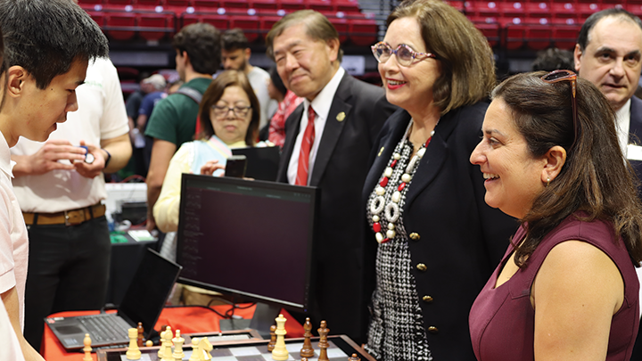 Kevin Tran shows his team's Artificial Intelligence chessboard to SDSU President de la Torre, Interim Provost Dr. William Tong, VP of Research and Innovation Hala Madanat and Dean Eugene Olevsky.