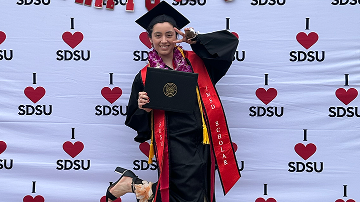 Photo of Fulbright U.S. Student Program recipient Gabriela Contreras in her cap and gown while holding up her degree