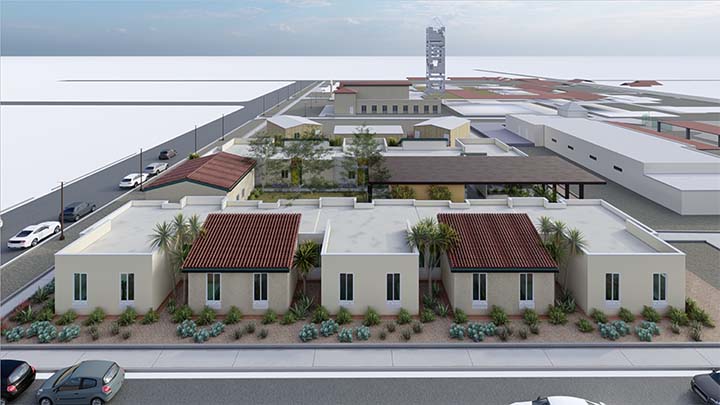 A rendition of a building site as seen from above. There are five separate wings of a one-story building, each with two vertical windows facing a street. In the background are additional buildings and a tower.