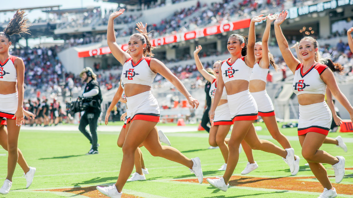SDSU cheerleaders run on the field and waive to fans at Snapdragon Stadium