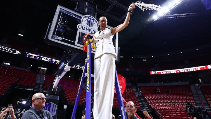 San Diego State head coach Stacie Terry-Hutson cuts down the net following the Aztecs triple overtime victory over Wyoming for the MW Tournament championship. (Credit: NCAA Photos)