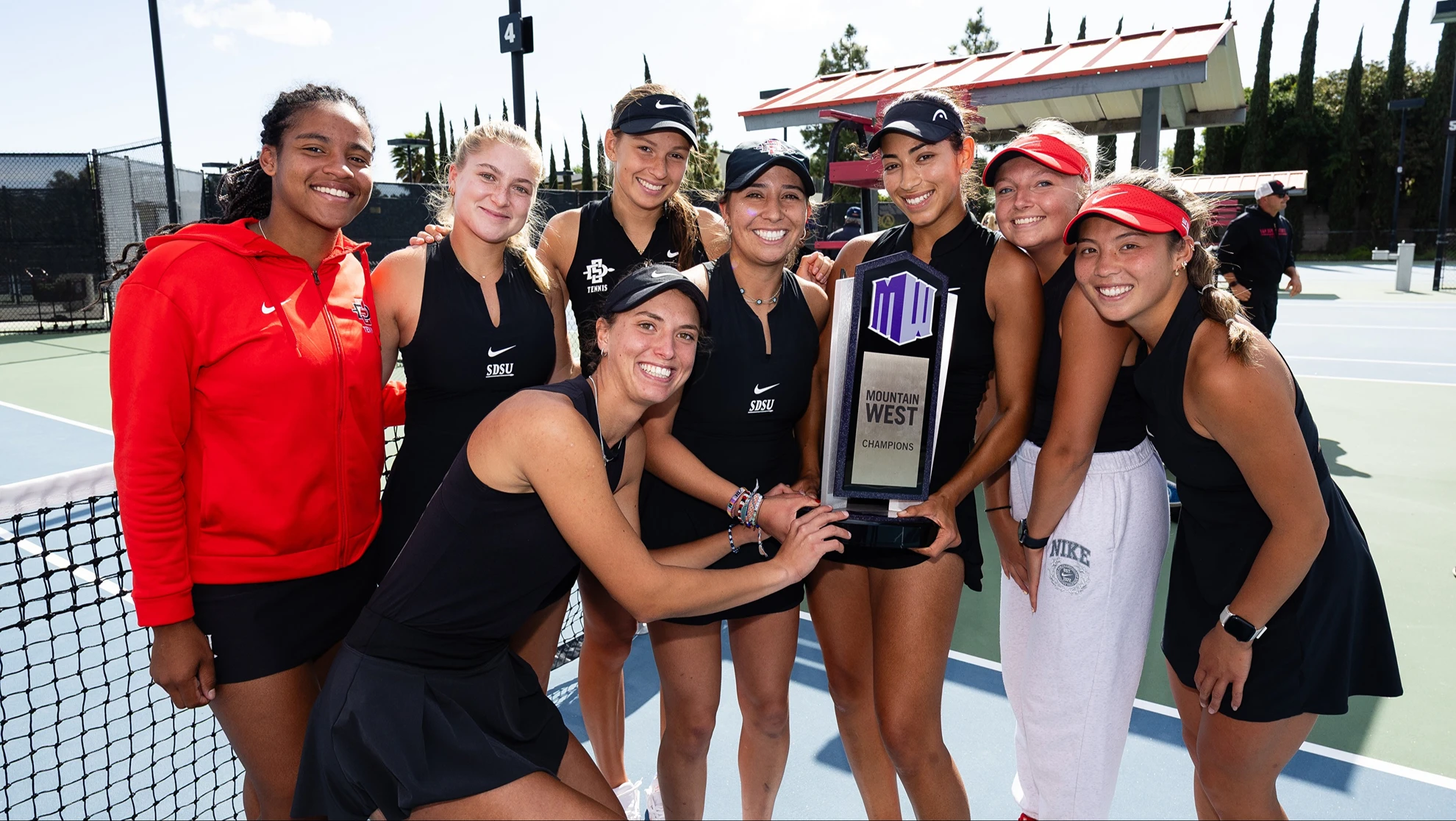 Women's Tennis team poses with the conference championshiop trophy.