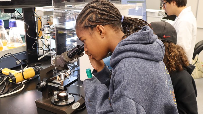 One of Beach’s students gets a microscopic view of algae samples in Zuniga’s lab (Bryana Quintana / SDSU)