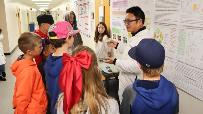 Associate Professor Changqi Liu, food scientist in the College of Health and Human Services, holds up a sample of freeze-dried guacamole to teach the fifth grade students about his NASA and USDA-funded project in collaboration with Zuniga and Assistant Professor Jing Zhao. (Bryana Quintana / SDSU)