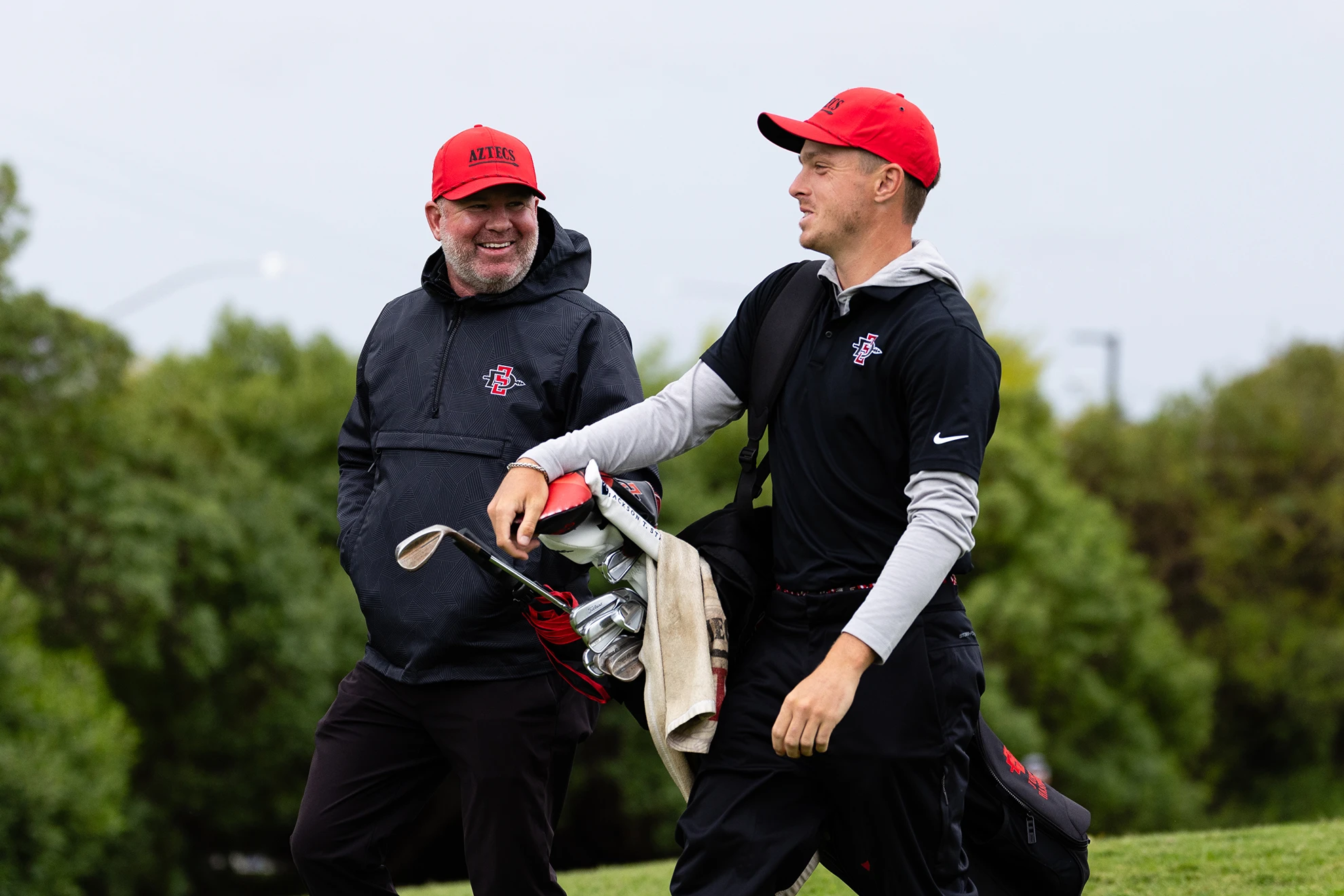 Aztecs Golf Coach Ryan Donovan walks the course with senior Justin Hastings. (Derrick Tuskan/SDSU)