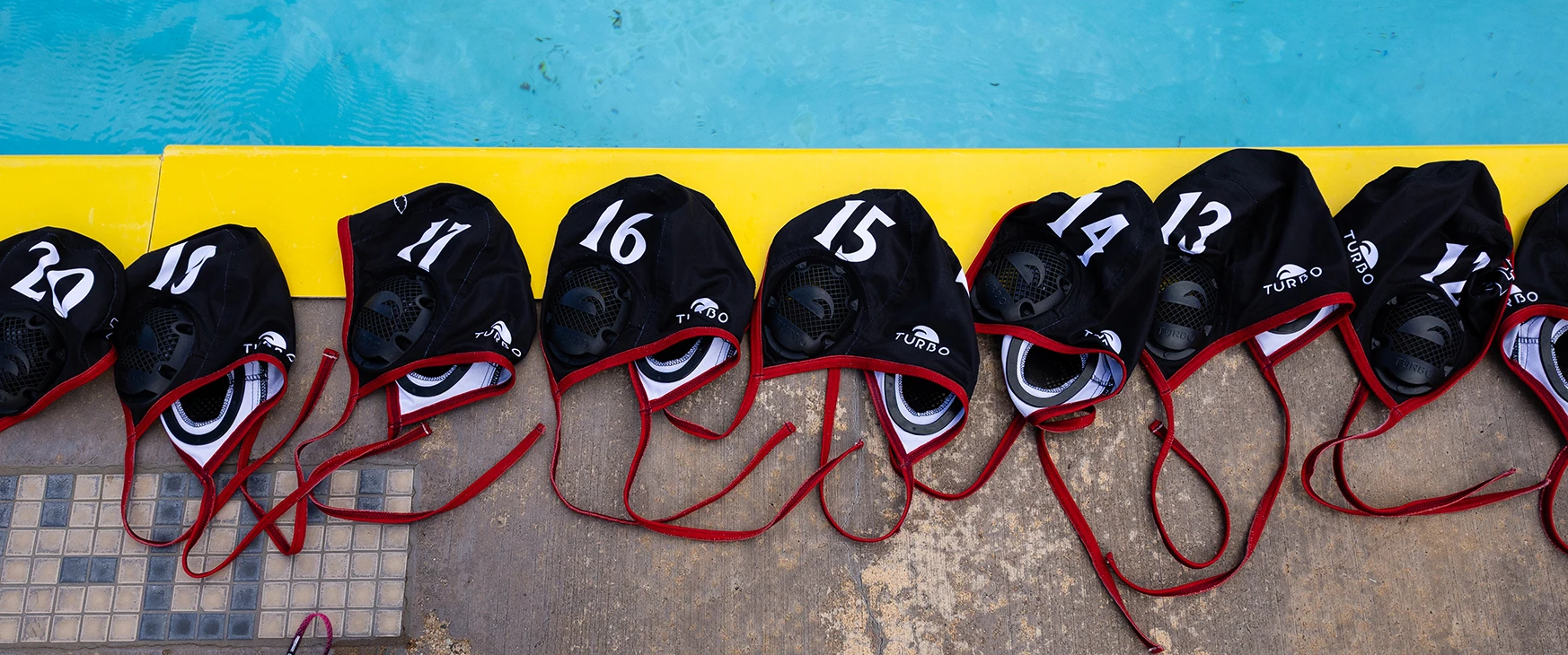 SDSU water polo caps along the pool deck