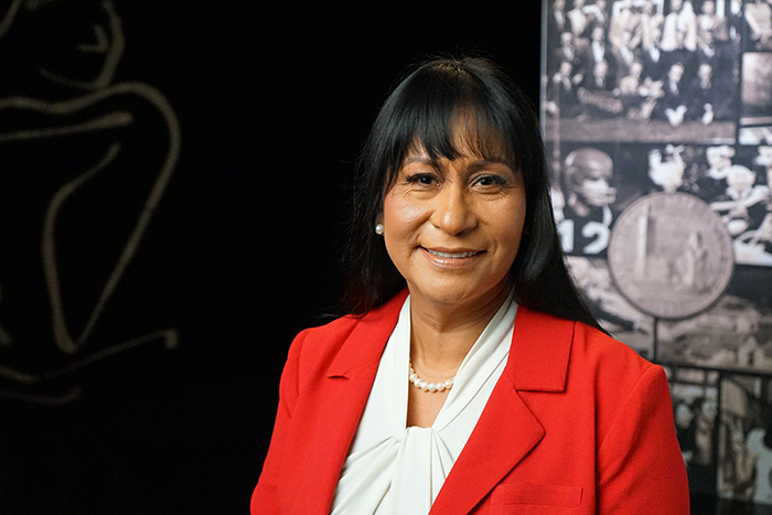 A woman smiling in front of a backdrop
