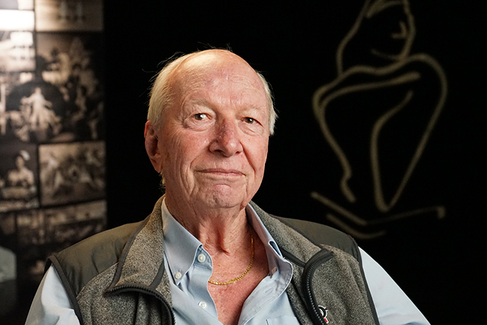 A man smiling in front of a backdrop 