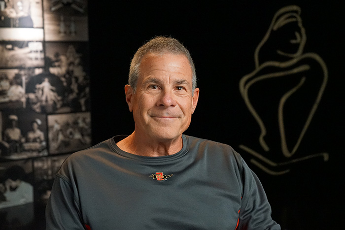 A man smiling in front of a backdrop 