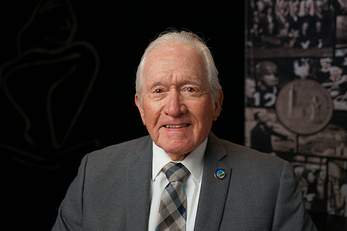 a man smiling in front of a backdrop