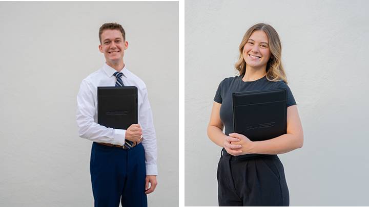 Two profesionally dressed students, a man and a woman, posed for separate pictures, each holding a leatherbound portfolio.