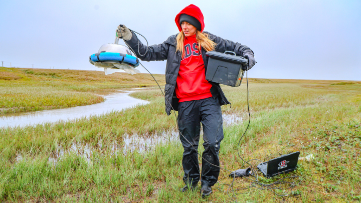 woman doing research on a grassland